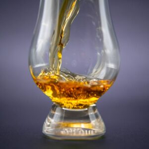 Close-up of golden whiskey being poured into an elegant glass.
