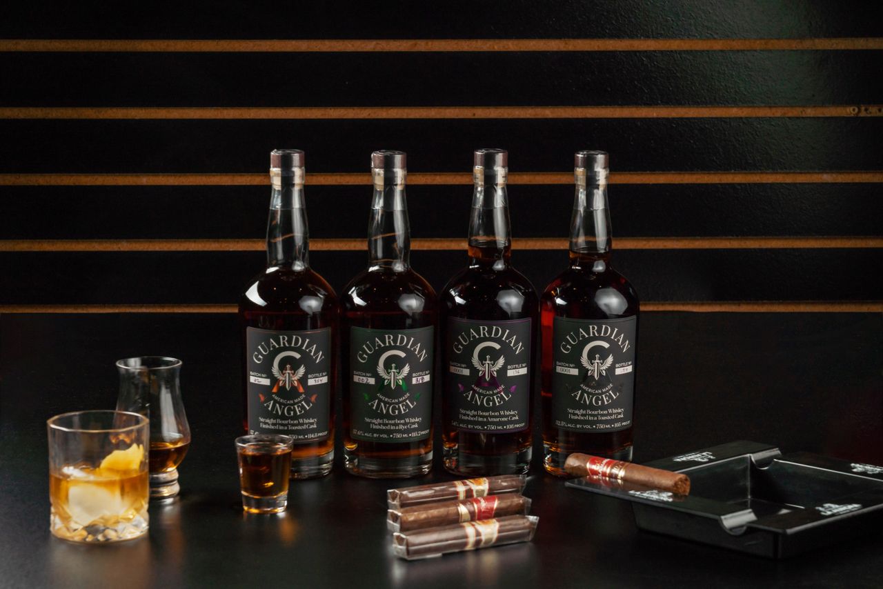 A stylish display of Guardian Angel whiskey bottles with cigars in a New Orleans bourbon bar setting.